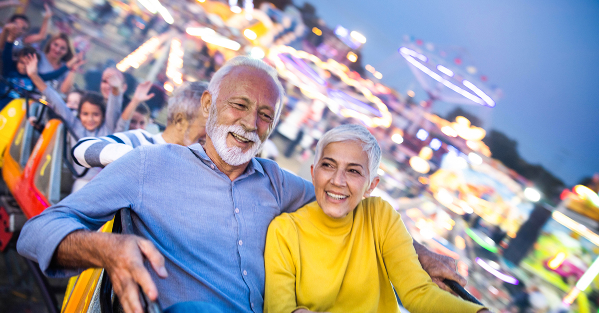 An older couple riding a rollercoaster